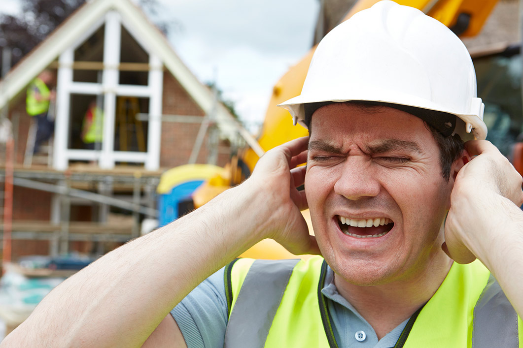 Industrial worker covering ear pain